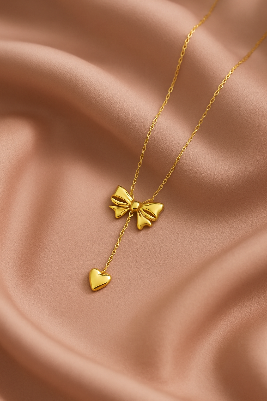 Gold necklace with bow and heart pendant